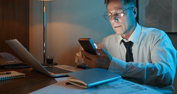 Businessman working overtime in dimly lit hotel room